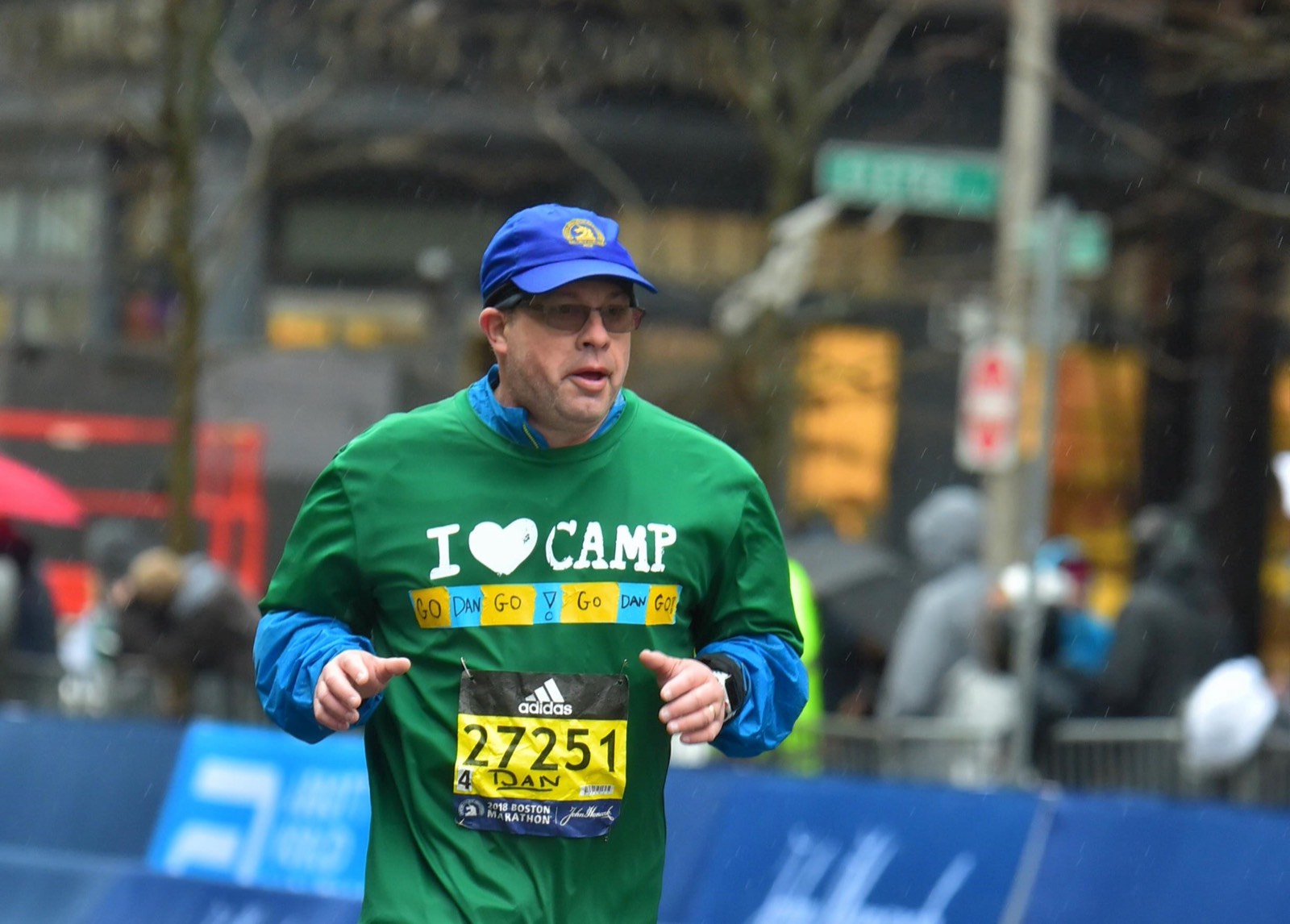 Dan Alperin holding his 2015 NYC Marathon finisher medal, wearing his Hole in the Wall Gang Camp charity shirt
