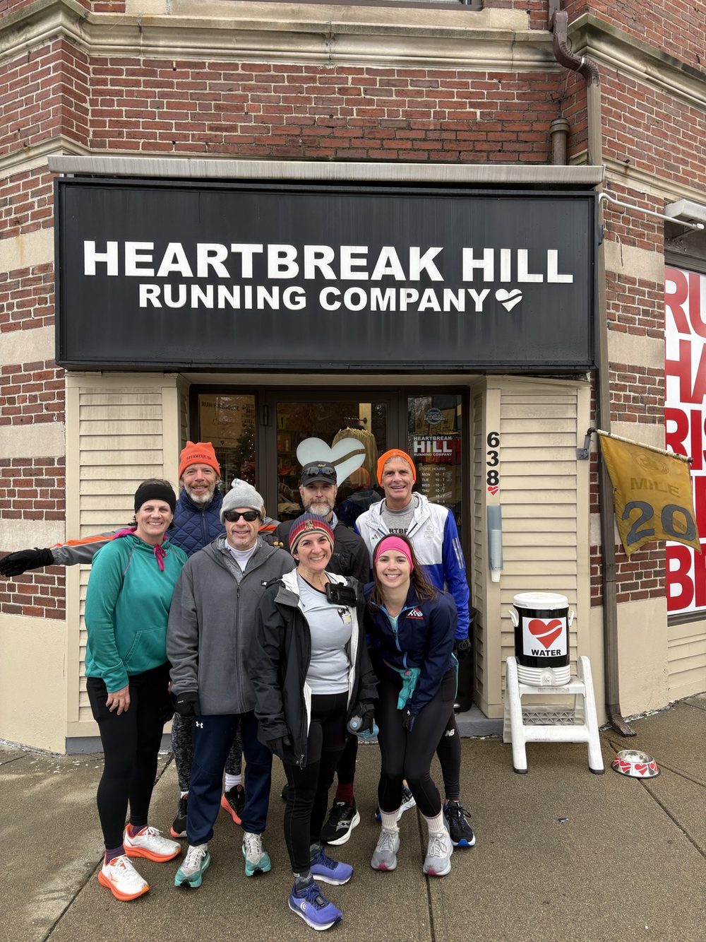 A group of runners gathered outside Heartbreak Hill Running Company in Boston on a cold morning